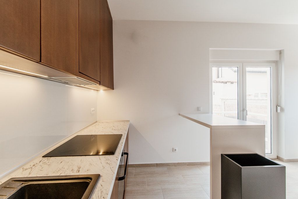 Bright condo kitchen with wood cabinets and stone counters