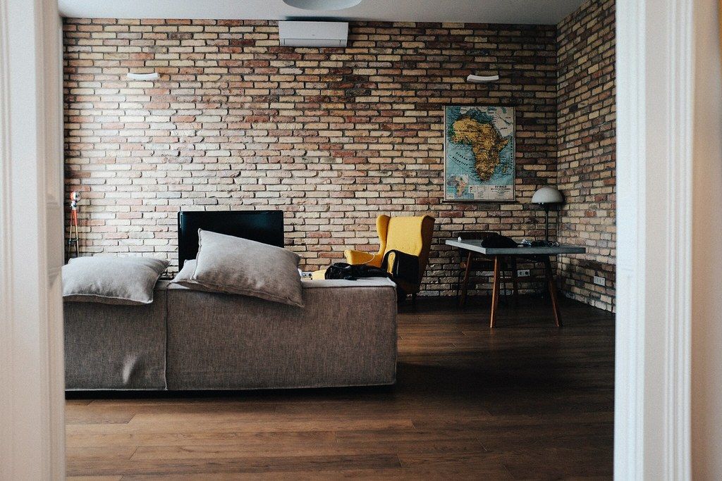 Loft living room with a brick wall and hardwood floors